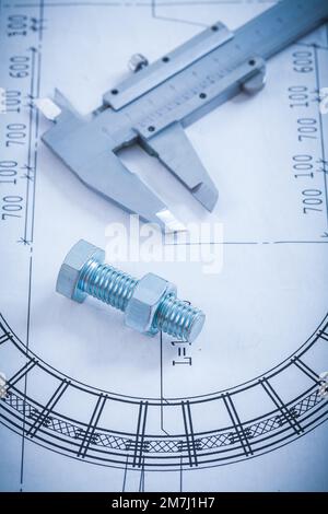 Stainless screw bolt with construction nut caliper on blueprint architecture and building concept. Stock Photo