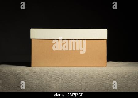 Front view on closed brown cardboard box on black background, copy space Stock Photo