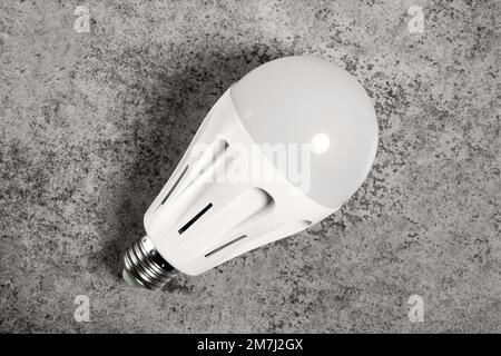 LED energy-saving lamp with E27 screw cap base on gray background Stock Photo