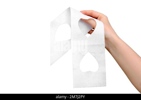 A woman's hand holds toilet paper with cut-out hearts, isolated on a white background Stock Photo