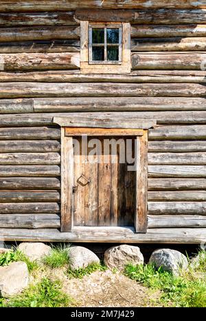 Door and small window in old wooden log house. Vintage wooden house Stock Photo