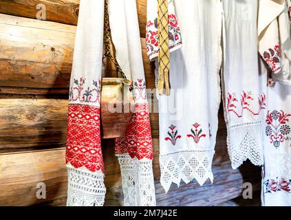 Vintage towels with traditional embroidered designs and a ceramic washbasin in an old wooden house Stock Photo