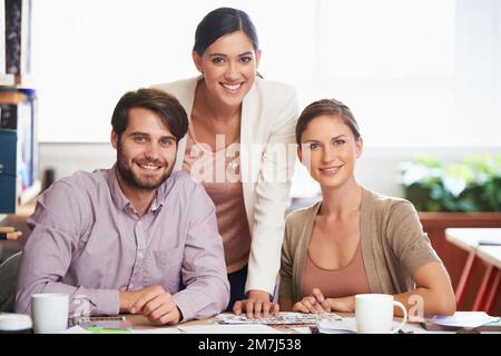 Teamwork makes for a better overall business result. three business associates working together on a project. Stock Photo