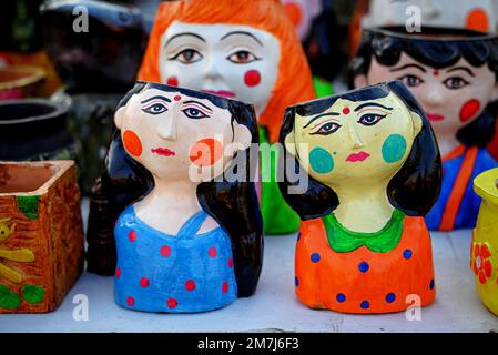 Beautiful handmade colorful painted terracotta pottery vase is displayed in a shop for sale in blurred background. Indian art and handicraft. Stock Photo