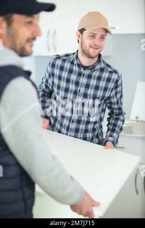 two men fitting new kitchen Stock Photo