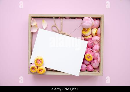 Gift box and rose buds and petals. Fresh flowers, craft envelope, blank card. Roses in a box pink roses, yellow roses. Fashion. Minimalism. Valentine' Stock Photo