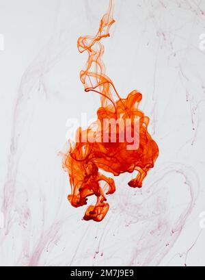 Food colouring swirling through water creating abstract patterns Stock Photo