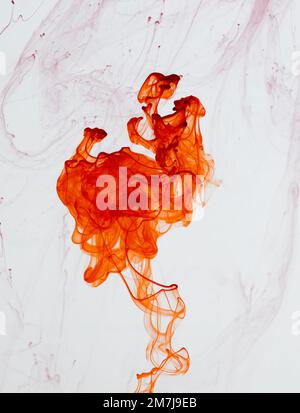 Food colouring swirling through water creating abstract patterns Stock Photo