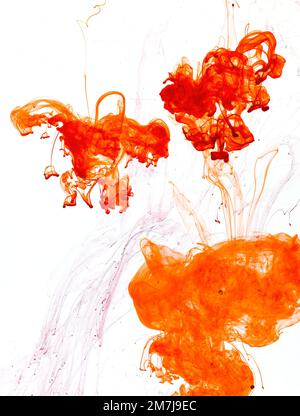 Food colouring swirling through water creating abstract patterns Stock Photo