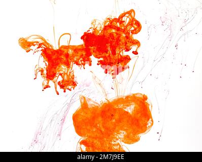 Food colouring swirling through water creating abstract patterns Stock Photo