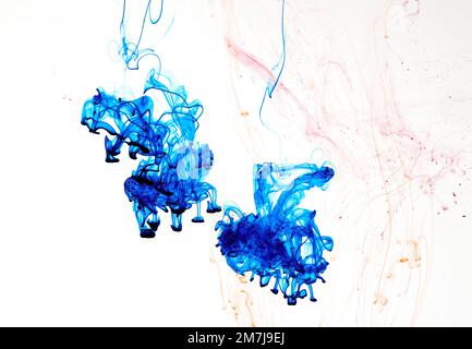 Food colouring swirling through water creating abstract patterns Stock Photo