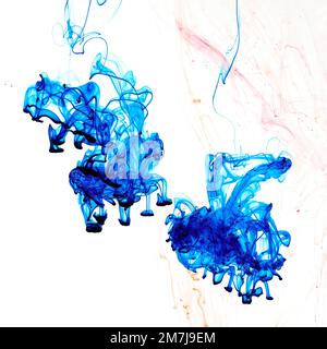 Food colouring swirling through water creating abstract patterns Stock Photo