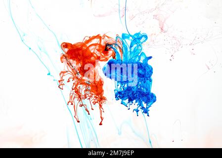 Food colouring swirling through water creating abstract patterns Stock Photo