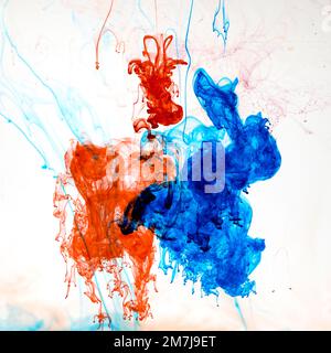 Food colouring swirling through water creating abstract patterns Stock Photo