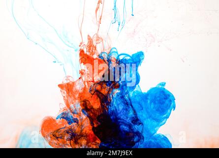 Food colouring swirling through water creating abstract patterns Stock Photo