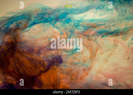 Food colouring swirling through water creating abstract patterns Stock Photo
