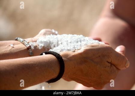 Dead Sea salt crystals in woman hands, natural minerals for health Stock Photo