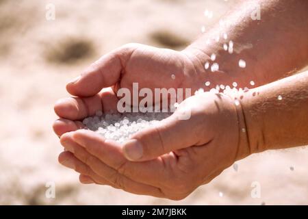 Dead Sea salt crystals in man hands, natural minerals for health Stock Photo