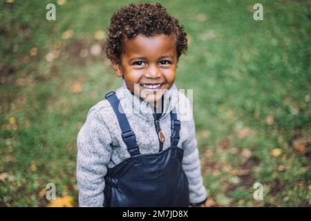Portrait of smiling boy standing in park Stock Photo