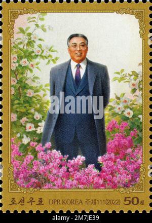 2022 North Korea Postage stamp. Kim Il Sung as Eternal Sun standing in flowers painting Stock Photo