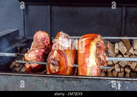 Roasted smoked pork leg ham grilling in street food market at Prague, Czech Republic Stock Photo