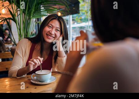 woman smiling to her friend during their date Stock Photo
