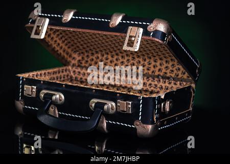 Retro, vintage open suitcase on a dark background. Stock Photo