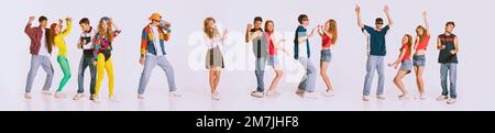 Group of young, cheerful people wearing 80s, 90s fashion style clothes dancing isolated over grey background. Disco party. Concept of youth, retro Stock Photo