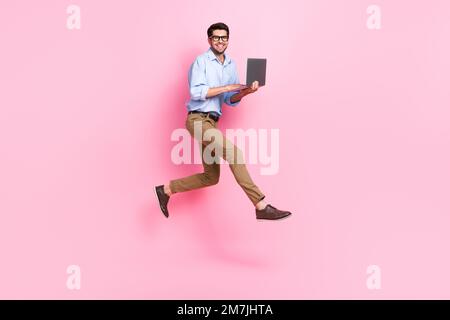 Full body size photo of jump professional freelance copywriter guy wear office clothes hold his new corporate laptop isolated on pink color background Stock Photo