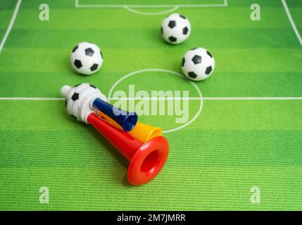 Football soccer triple fan trumpet with toy football on green grass Stock Photo