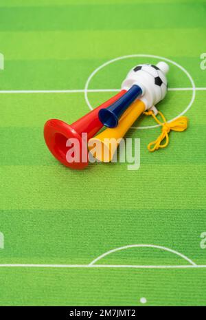 Football soccer triple fan trumpet with toy football on green grass Stock Photo