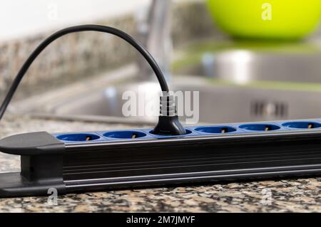Close up of a dangerous damaged electrical cord a tabletop at kitchen Stock Photo