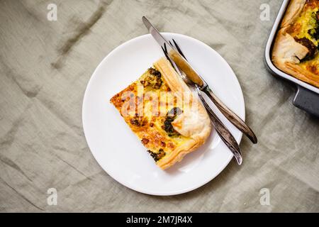 Sliced traditional french open quiche pie with cheese and broccoli Stock Photo