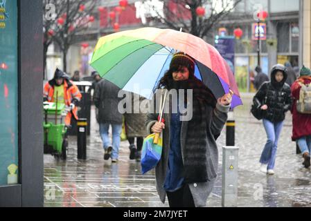 Manchester, UK, 10th January, 2023. Heavy rain in city centre Manchester, England, UK. People with essential umbrellas. The Met Office has issued three yellow warnings for “persistent heavy rain” throughout the day, covering much of Wales and north-west England. Credit: Terry Waller/Alamy Live News Stock Photo