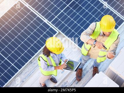 Top view, teamwork and engineers with tablet on solar roof for maintenance, inspection or installation. Solar energy, renewable energy and man and Stock Photo