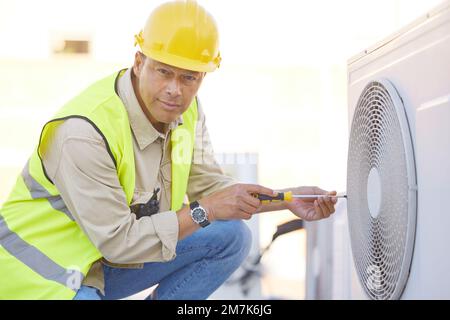 Air conditioner, repair and portrait of man on roof for maintenance, construction and fixing appliance. Ac repair, construction and handyman Stock Photo