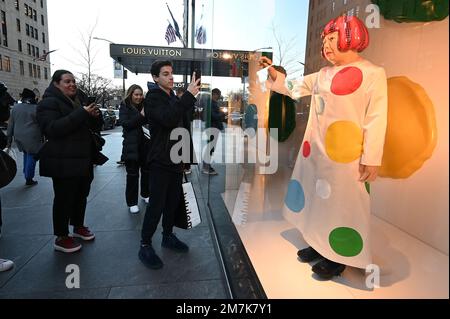 A young child reacts looking at a realistic looking Yayoi Kusama robot  painting spots on the window of the luxury retailer Louis Vuitton's Fifth  Avenue store, New York, NY, January 9, 2023.