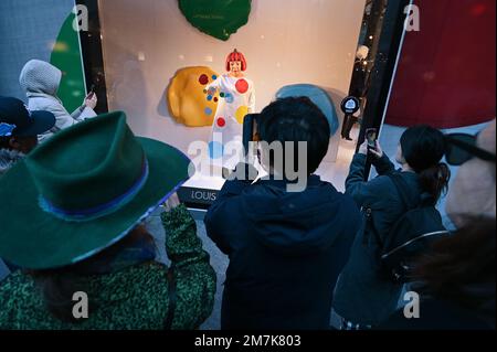 A young child reacts looking at a realistic looking Yayoi Kusama robot  painting spots on the window of the luxury retailer Louis Vuitton's Fifth  Avenue store, New York, NY, January 9, 2023.