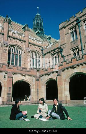 Australia. Sydney. Three international students sitting on the lawn of the University of Sydney. Stock Photo
