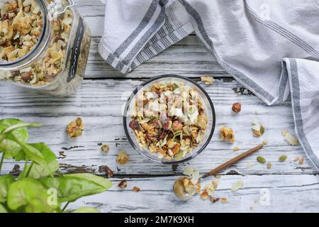 Vegan keto Granola made with pecans, hazelnuts, unsweetened coconut, sunflower seeds, pepita seeds and sweetened with erythritol. Low carb nut milk. Stock Photo