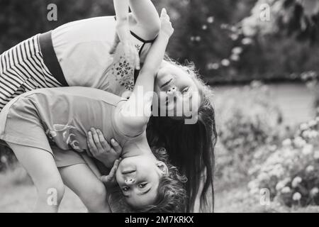 Black and white Portrait of Two Cute little girls embracing and laughing at garden. Happy kids outdoors Stock Photo