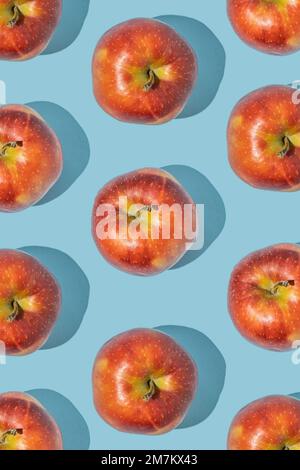 Pattern made of fresh red apples on blue background. Minimal fruit concept. Stock Photo