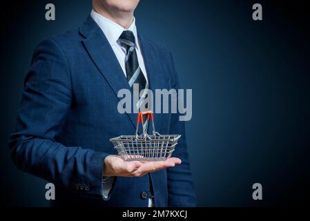 Businessman holding a shopping basket on his hand Stock Photo