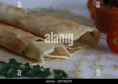 Thin crispy Indian crepe made of brown top millet and lentils. A healthy gluten free fermented breakfast dish with millet, called millet ghee roast do Stock Photo