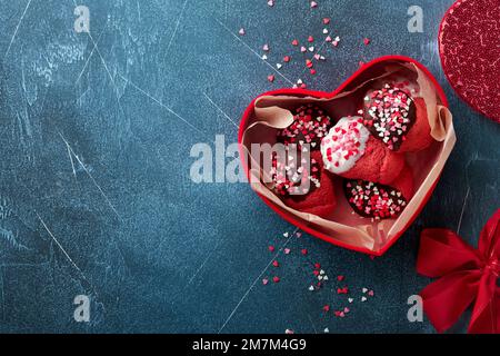Valentines day cookies. Shortbread cookies with glaze white and dark chocolate and heart sprinkles in red box on dark blue background. Mothers day. Wo Stock Photo