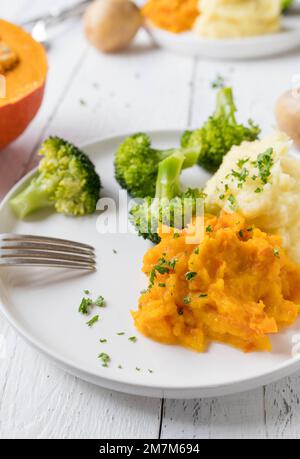 Plate with healthy, warm and gluten free side dishes. Such as broccoli, mashed potatoes and red kuri squash puree Stock Photo