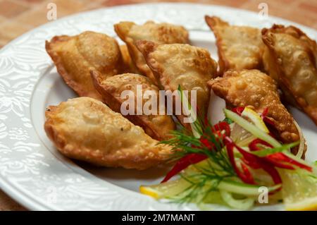 Asian fried dumplings on white dish. Fried dumplings gyoza with soy sauce, and chopsticks, selective focus. Stock Photo
