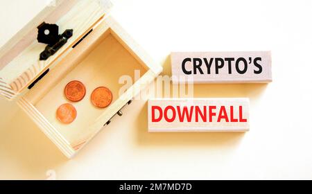 Crypto downfall symbol. Concept words Cryptos downfall on wooden blocks. Beautiful white table white background. Wooden chest with coins. Business and Stock Photo