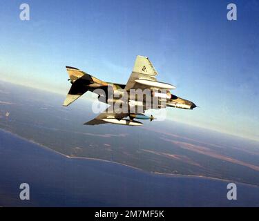 An air-to-air right underside view of an F-4E Phantom II aircraft equipped with an SUU dispenser on right wing, Pave Tack center mounted and an LGB-10 Mark 84 on left wing. Base: Eglin Air Force Base State: Florida (FL) Country: United States Of America (USA) Stock Photo