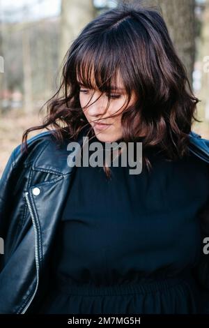 Young woman looking down in forest Stock Photo